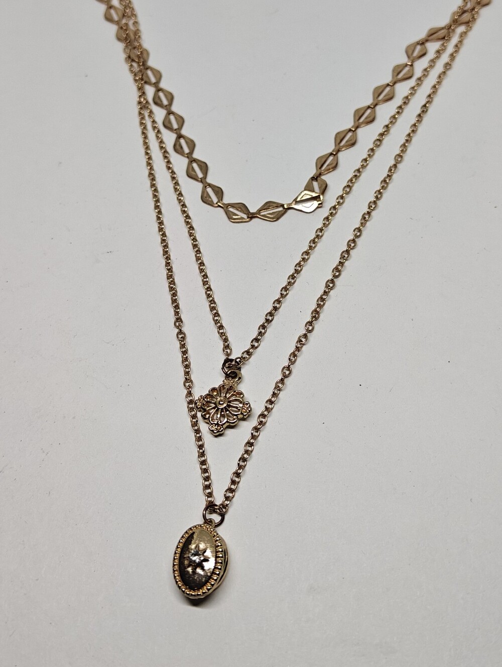 Three tier gold tone chain necklace with a Victorian style locket pendant